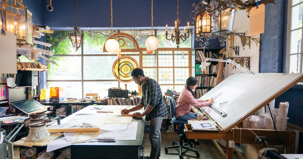 Architect working in a studio with tall windows