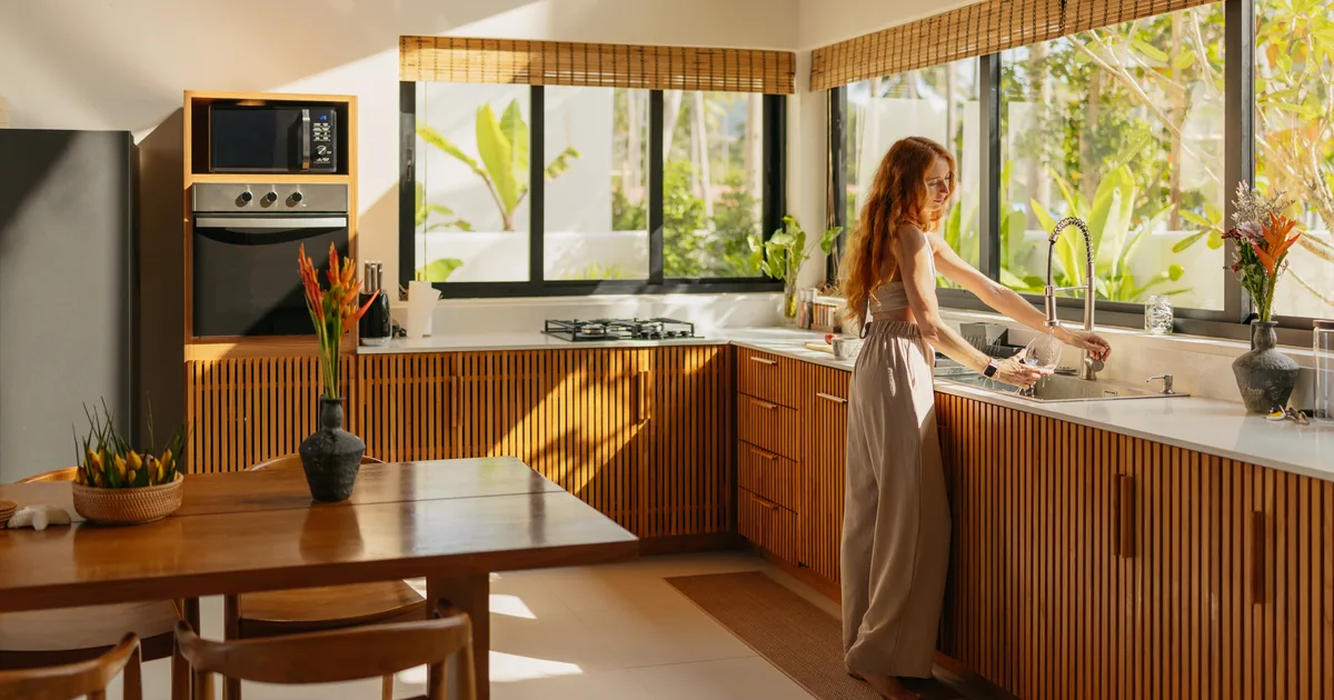 Woman in a kitchen with long afternoon shadows