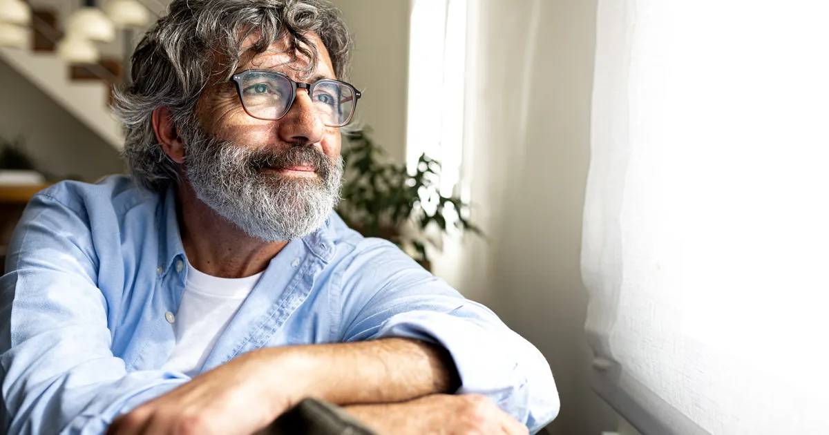 Man looking out a window in soft light
