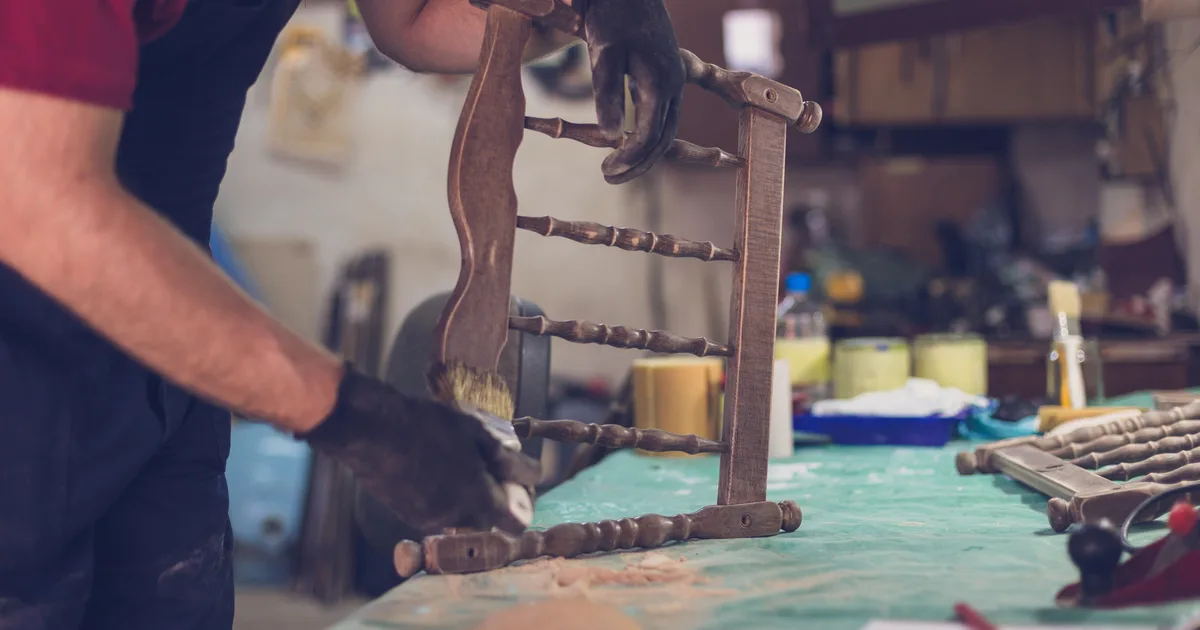 Man repainting a restored crib