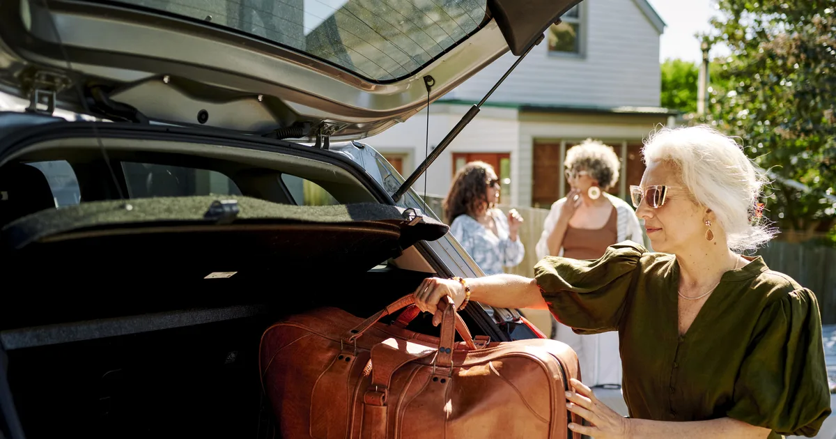 Woman loading a duffel bag into a car