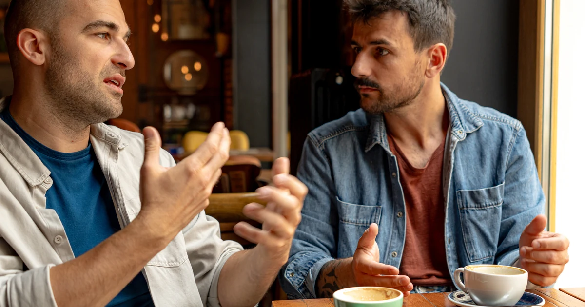 Men in attentive conversation at a cafe