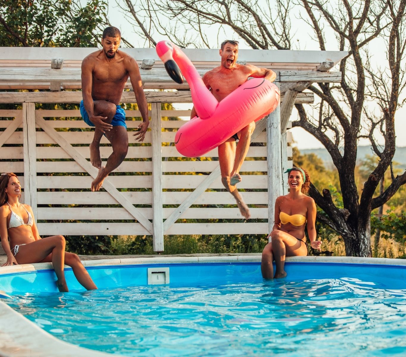 Friends and Family playing in a backyard pool, jumping into the water with Flamingo floaty