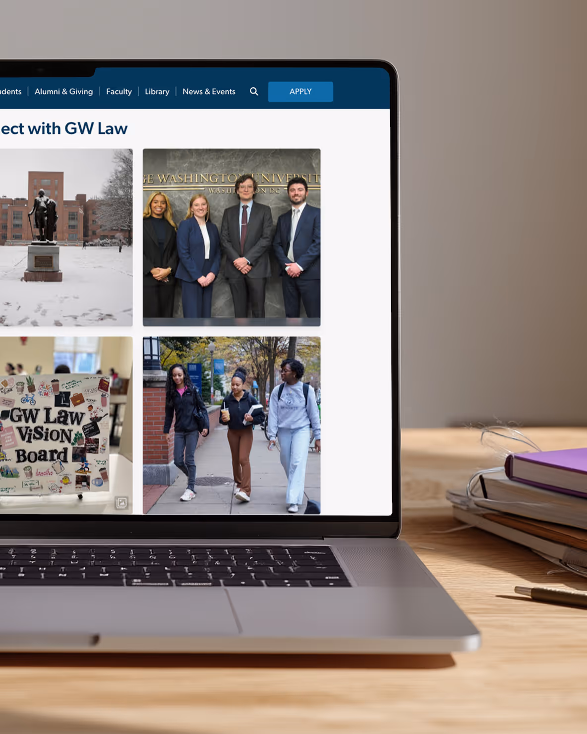 Laptop displaying GW Law website with social media photos of students, campus statues, vision board, and campus walk.