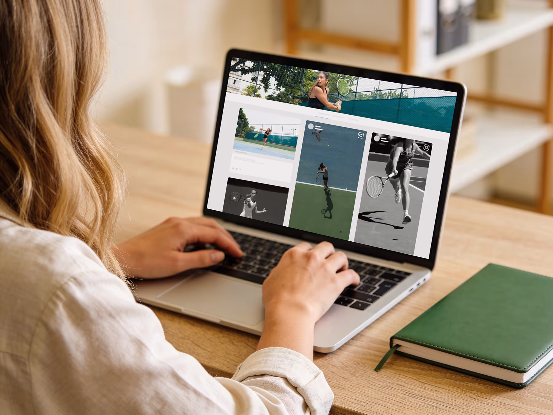 Person using a laptop on a wooden table with tennis player social media posts displayed on the screen and a green notebook beside the laptop.