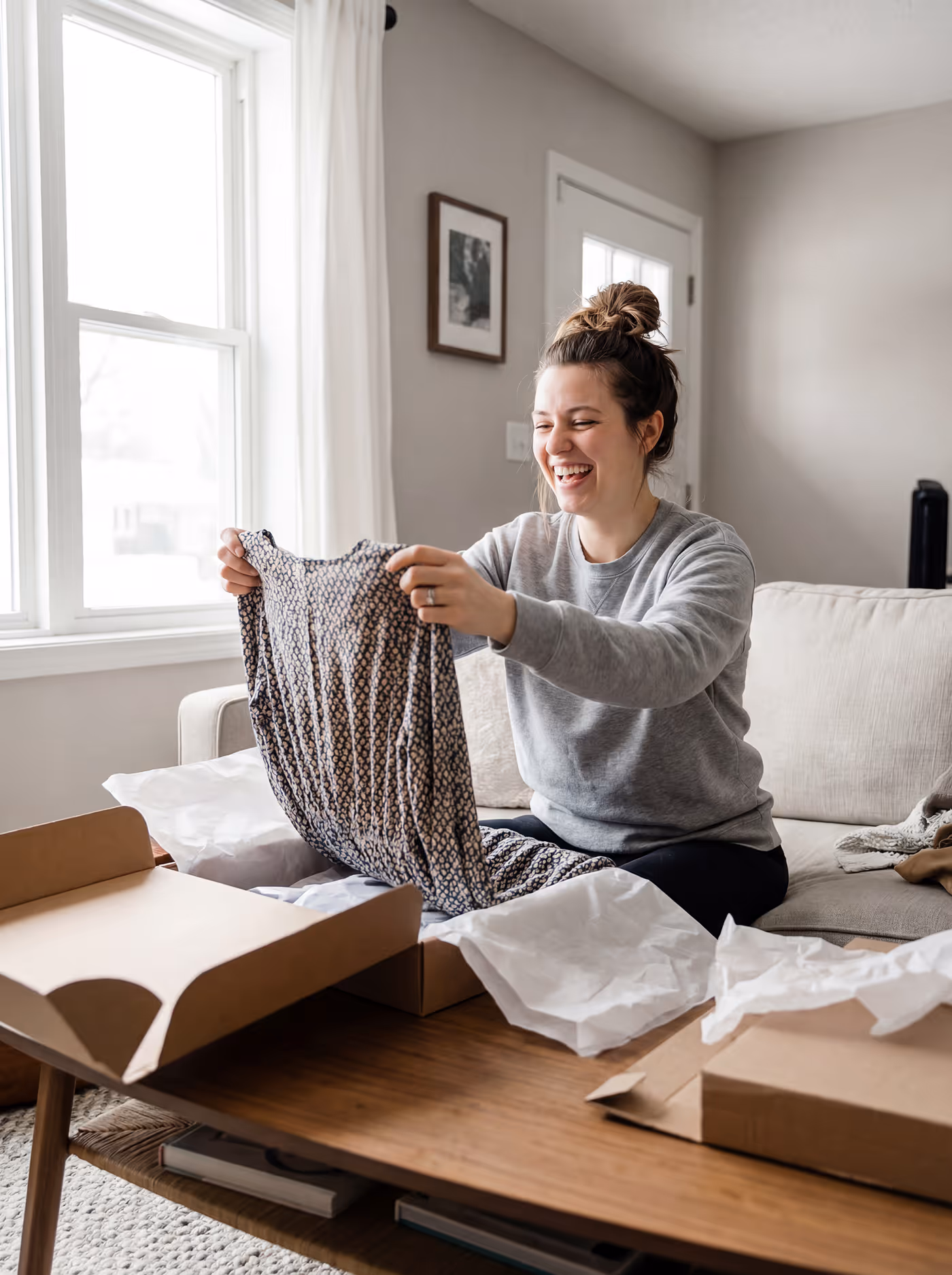 A women unboxing a a a cloth package, referring to customer photo who shopped through shoppable galleries