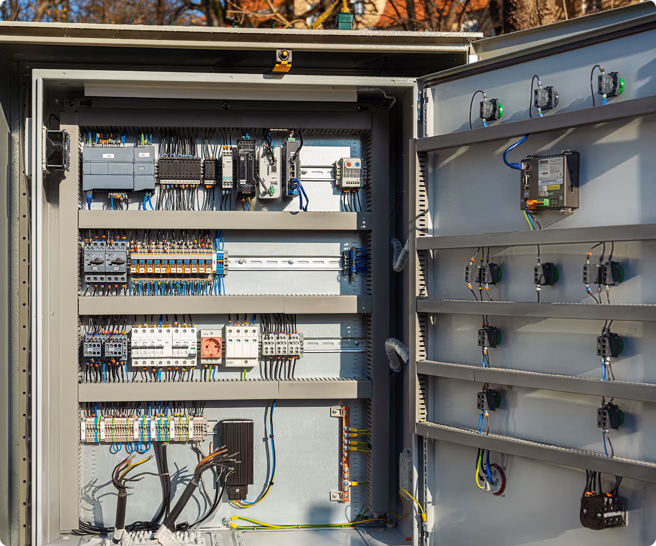 A complex electrical enclosure with neatly organized cables, switches, and automated control systems for industrial machinery