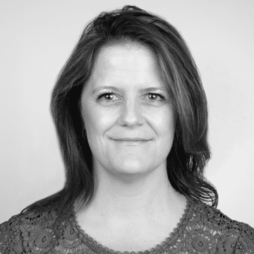 Black and white headshot of a woman with shoulder-length hair wearing a patterned top.