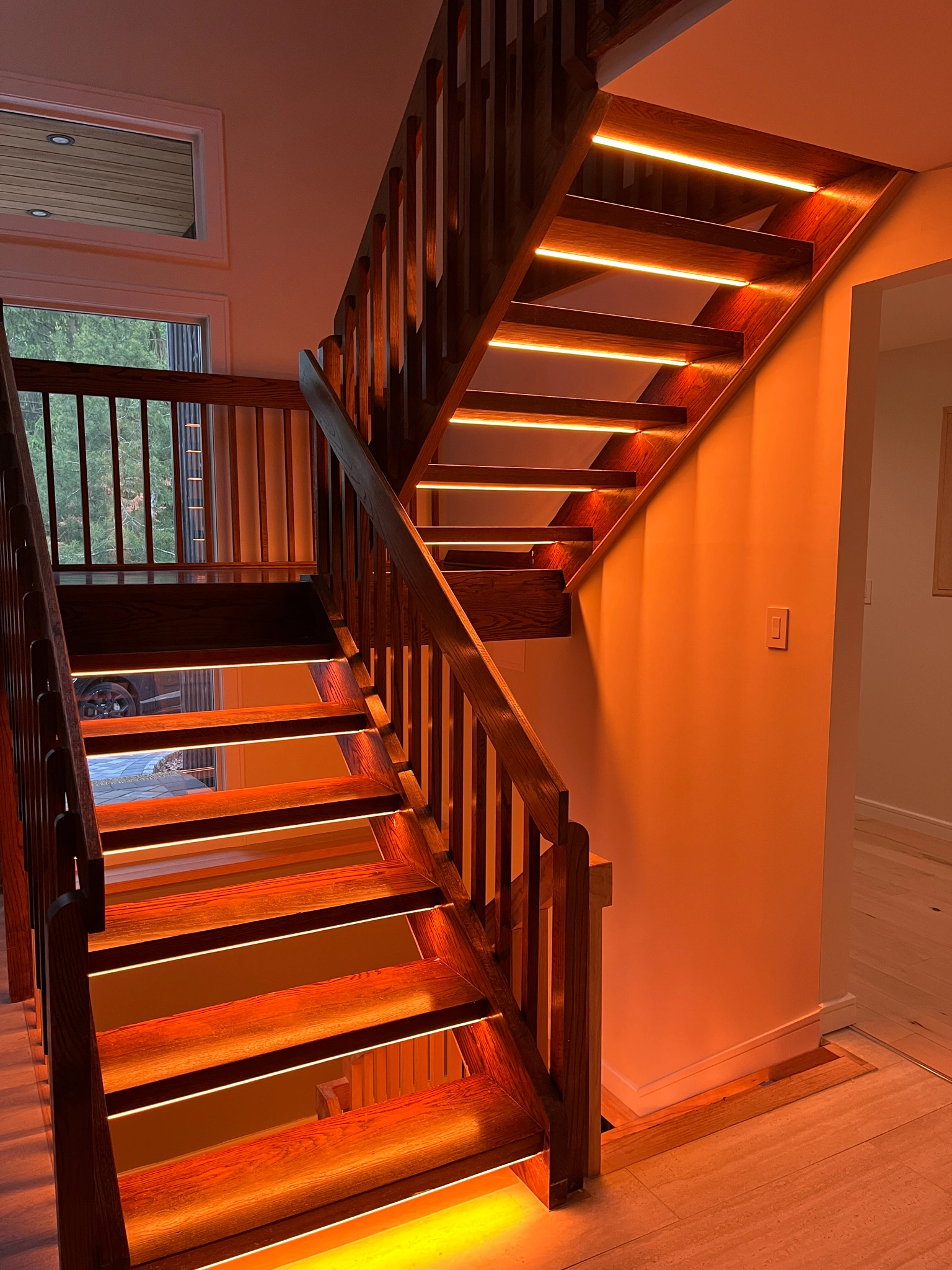 image of a staircase lit with under cabinet Lutron Lighting strips, installed by iQUARTERS.