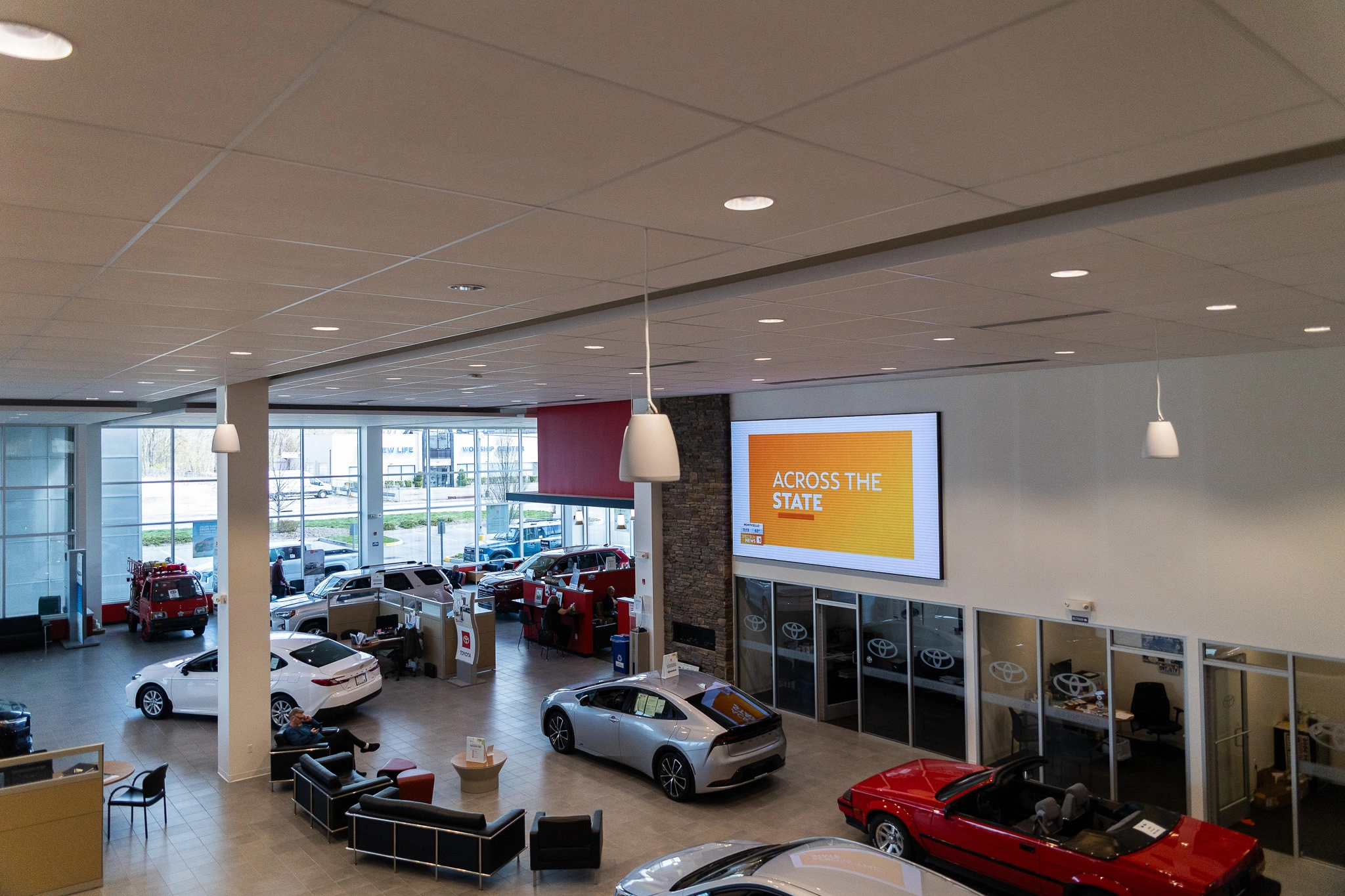 Intelligent lighting and integrated audio visual systems installed in the showroom of Toyota dealership Johnston's Toyota, featuring digital displays, ambient lighting, and modern customer experience technology