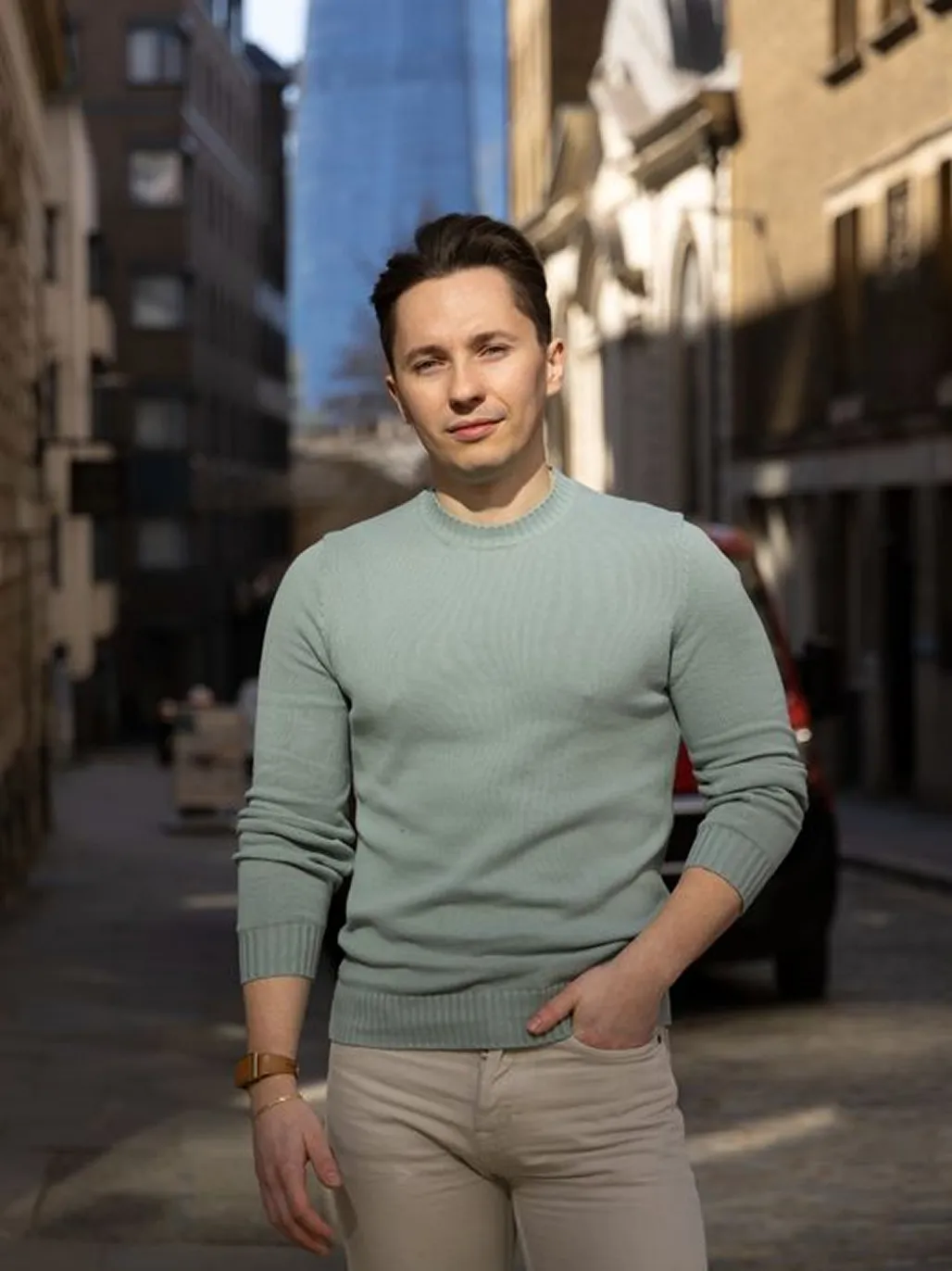 Bogdan Mihalache standing on a sunlit urban street with buildings in the background.