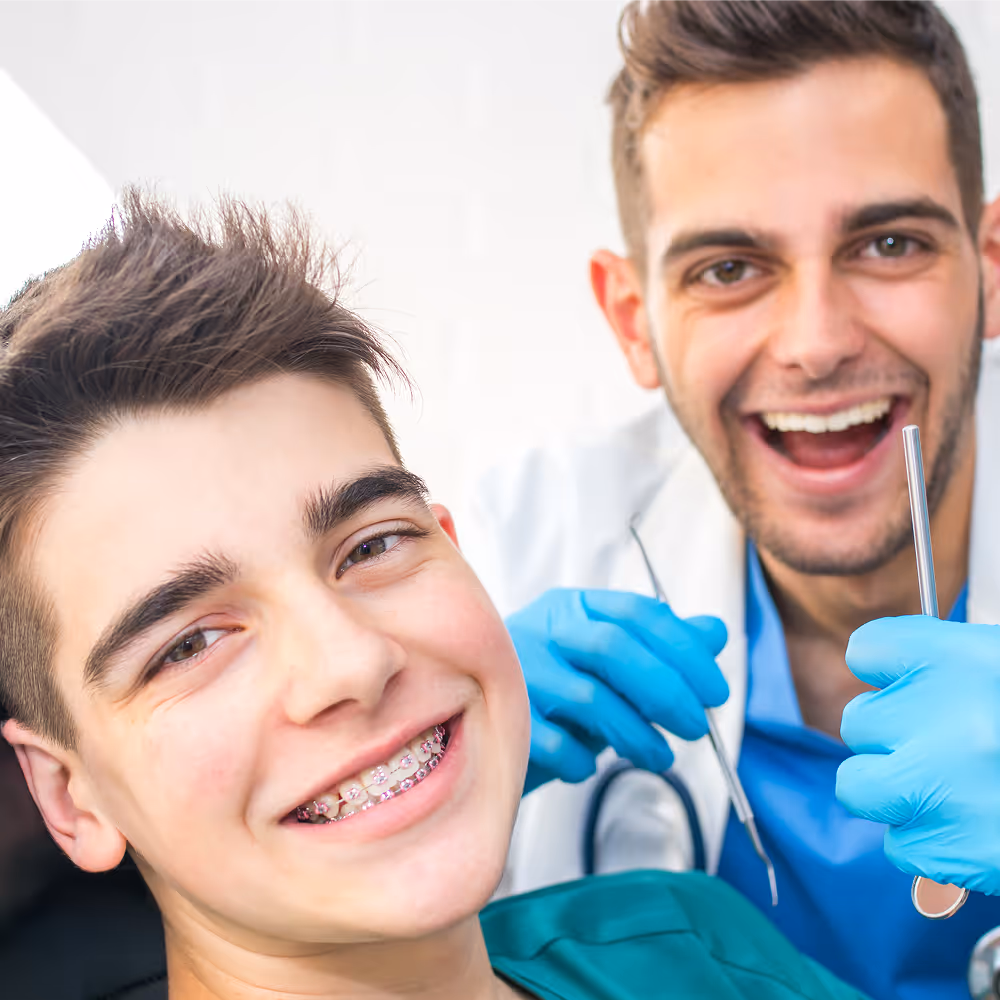 Teen smiling with clear aligners during treatment