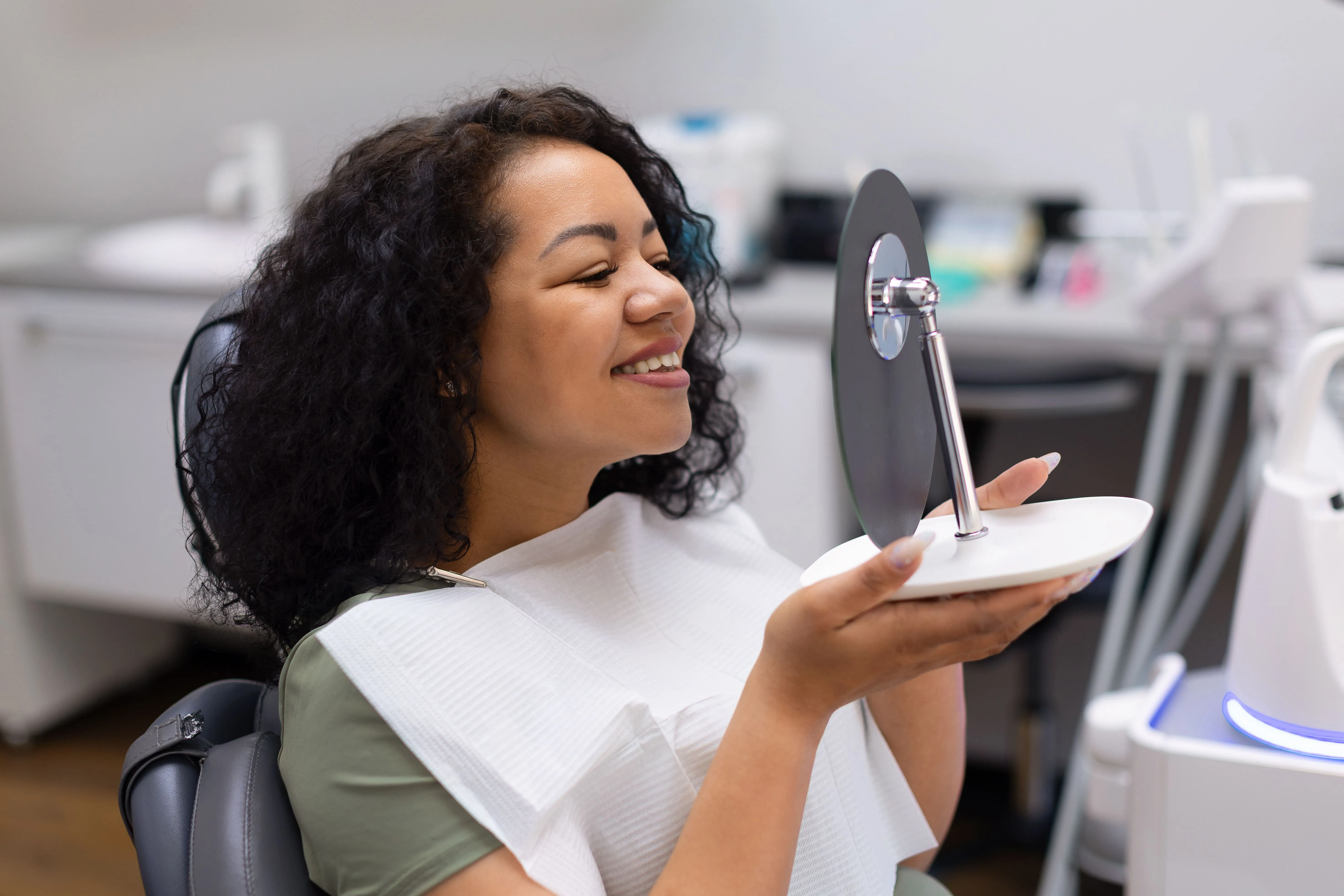 Patient viewing her smile during a cosmetic dental visit near Nutley, NJ