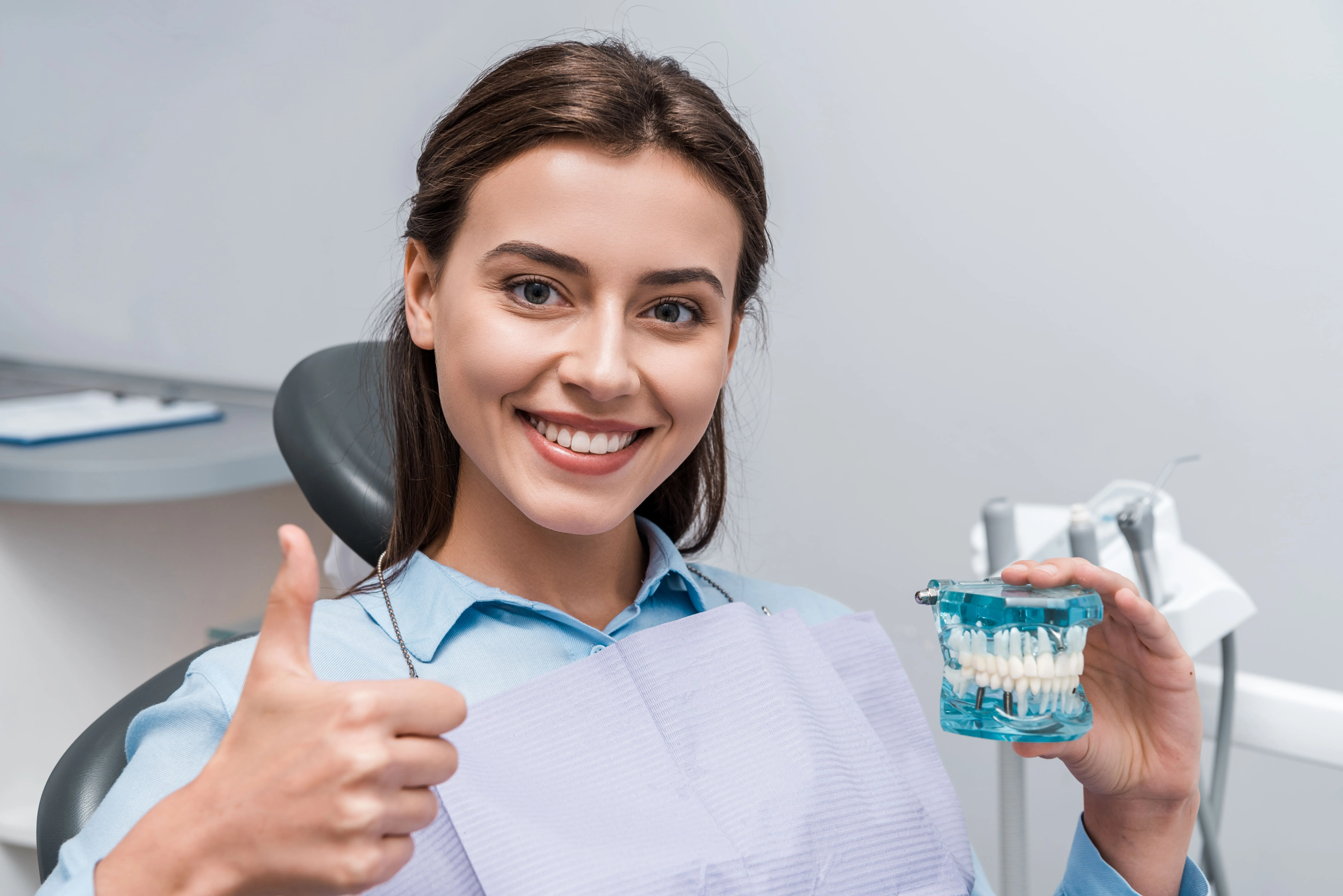 Patient holding a dental model during a smile makeover consultation near Garfield, NJ