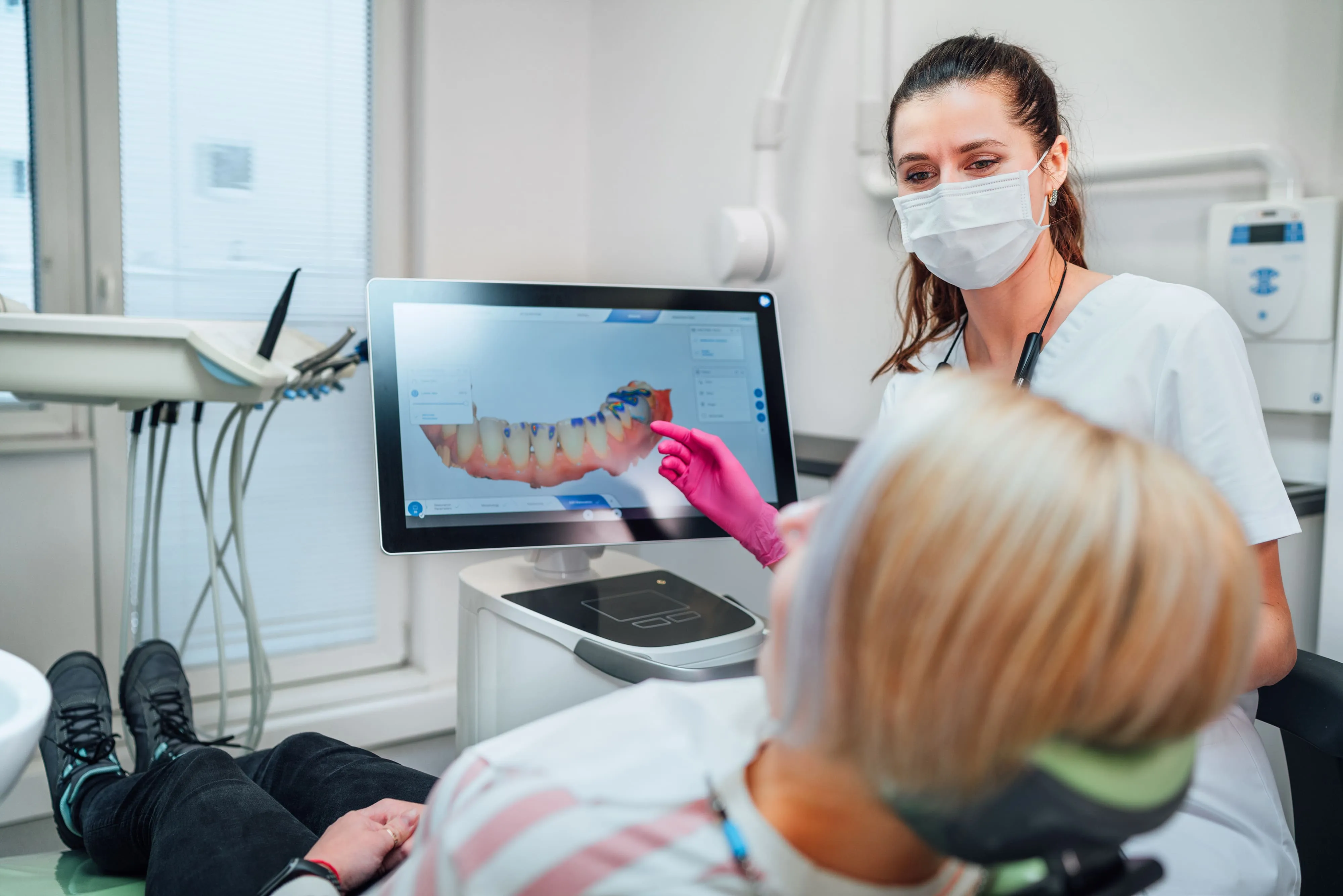 Dentist reviewing a digital full-arch implant scan with a patient near Garfield, NJ