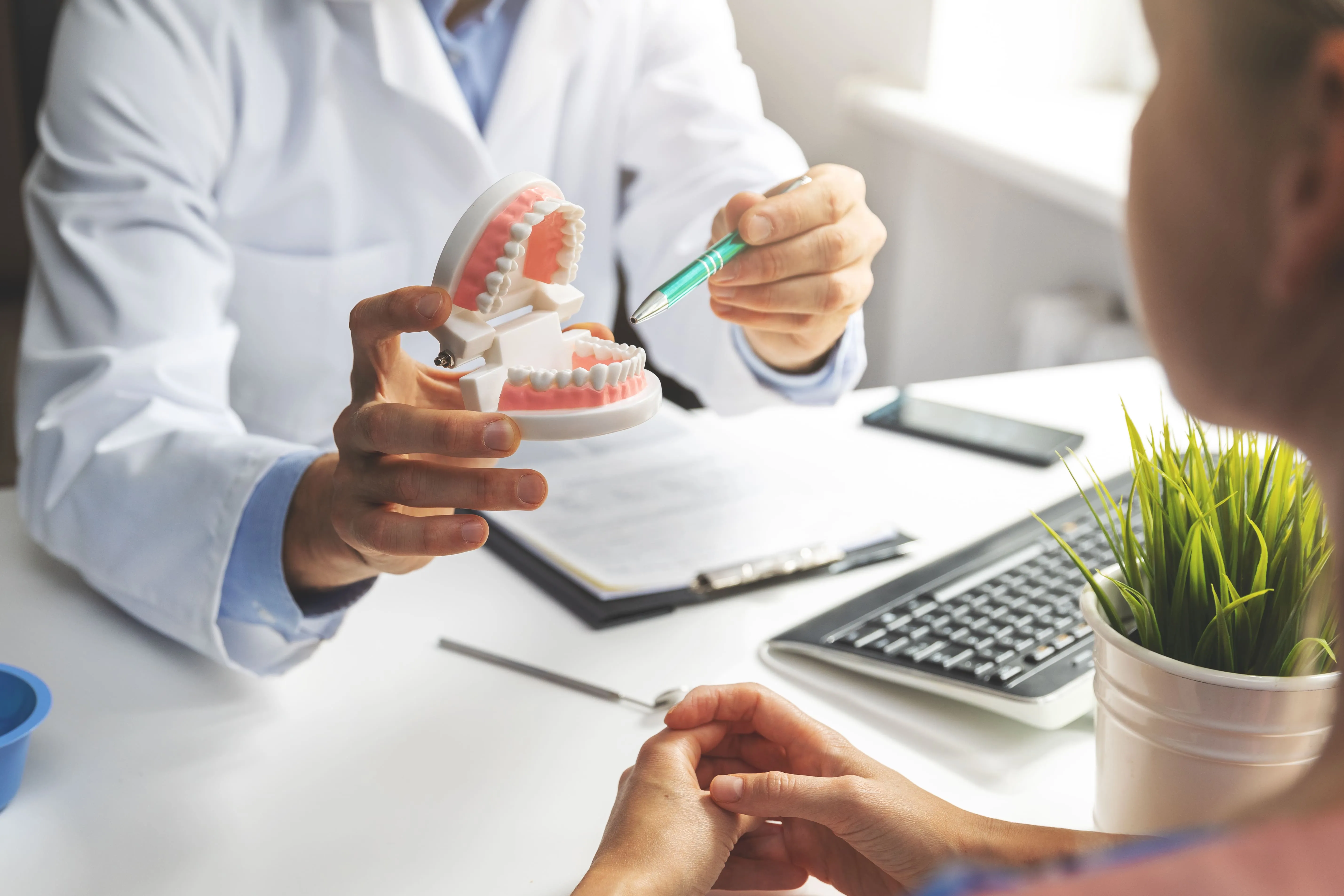 Dentist comparing implant-supported restoration options with a patient near Nutley, NJ