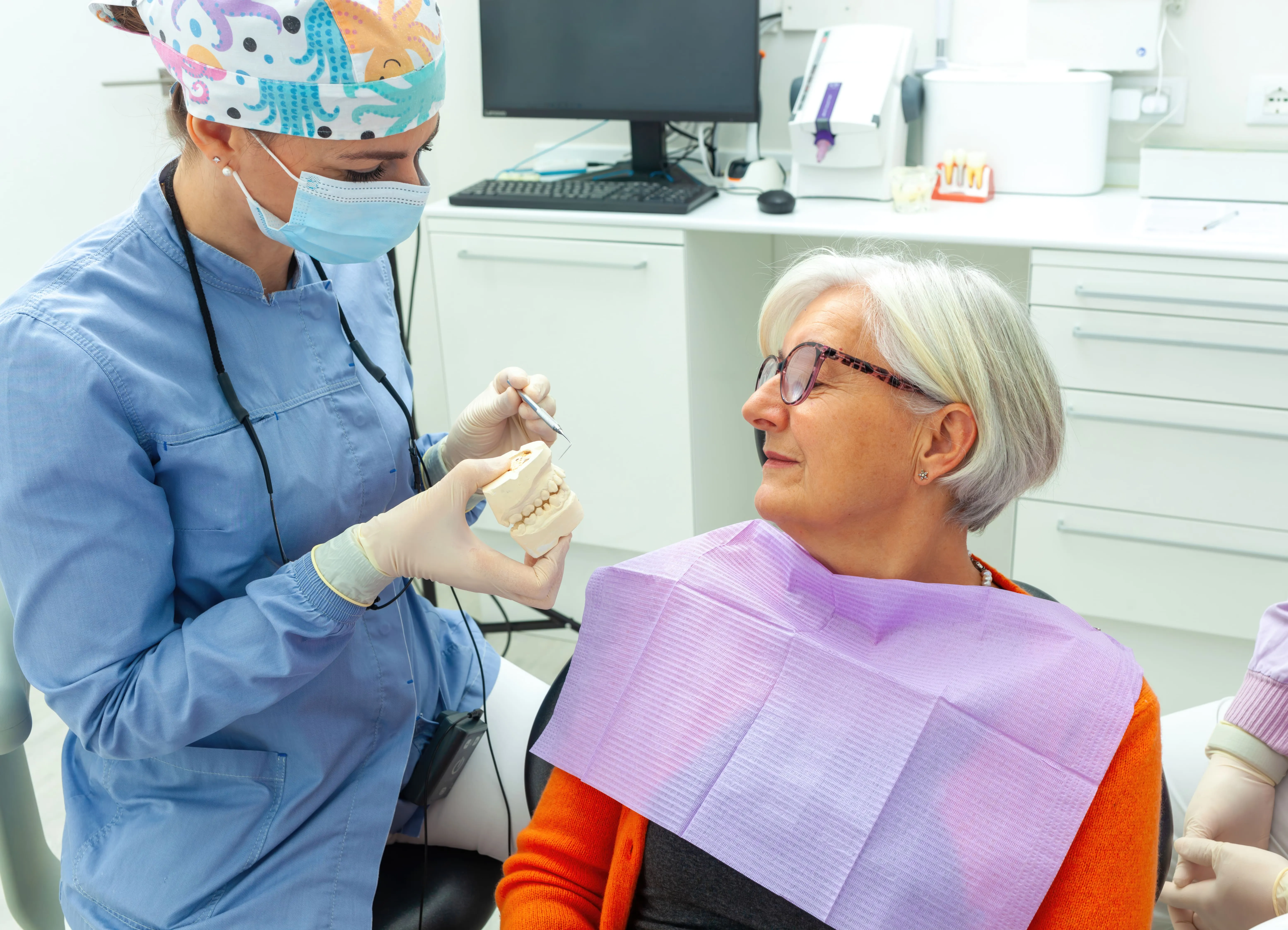 Dentist discussing full-arch implant treatment with an older patient near Elmwood Park, NJ