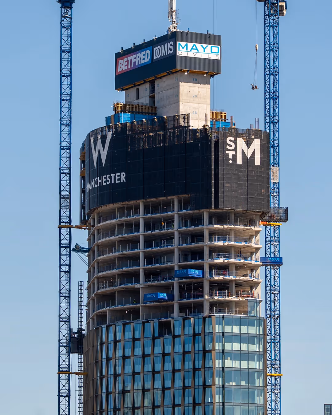 Wide photo of the new W building under construction in Manchester city centre a featuring anodised aluminium facade.
