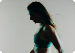 Silhouette of a person in athletic wear against a light background.