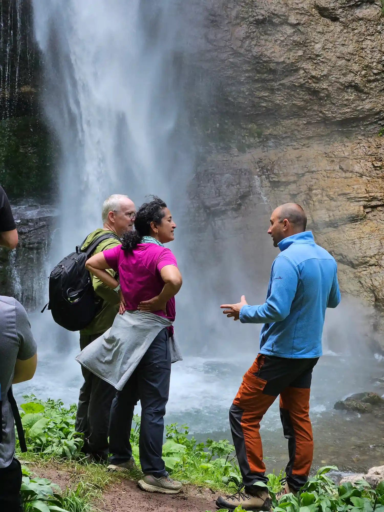 A professional tour guide explaining the history of Perućica primeval forest to a group of hikers at Skakavac waterfall