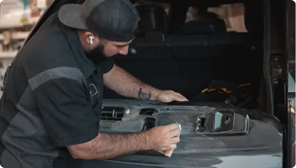 Estimator inspecting collision damage to write a repair estimate