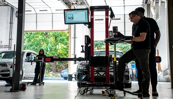 ADAS calibration equipment set up in front of a vehicle after a collision repair
