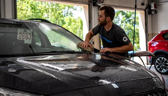 Technician performing a final quality check on a repaired vehicle