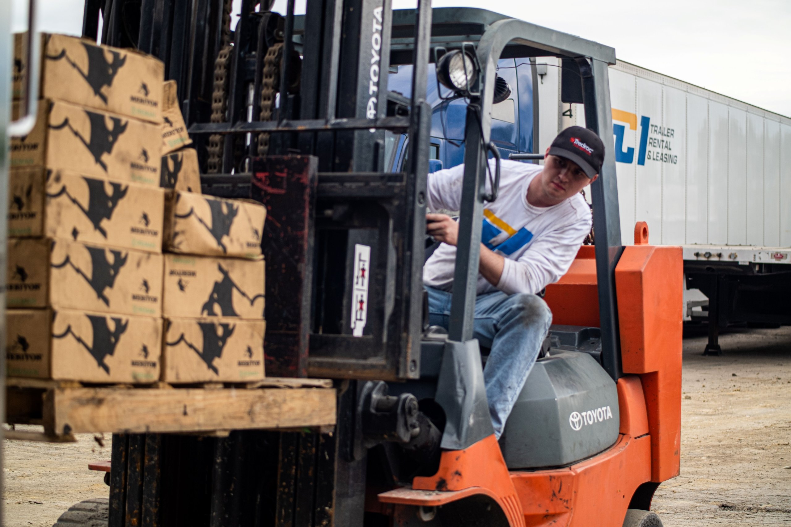 Forklift loading palletized cases into a dry van