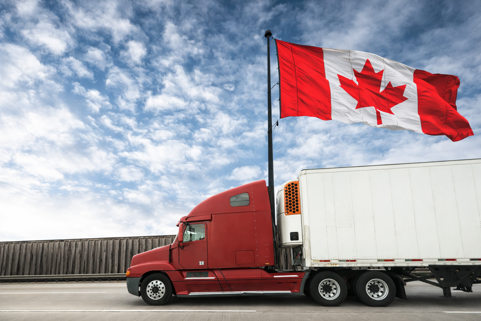Canadian flag above a tractor-trailer