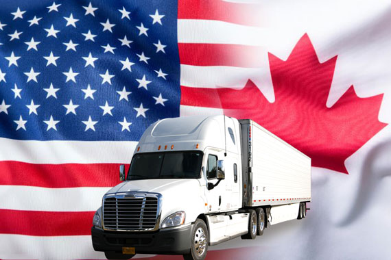 Tractor-trailer in front of US and Canadian flags for cross-border freight