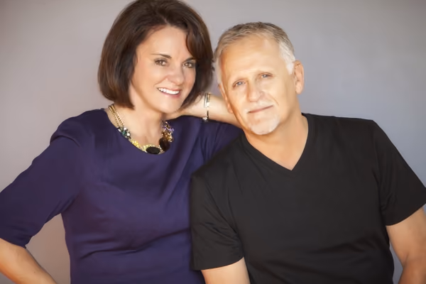 Portrait of Dr. Dannelly and his wife Kathy smiling in a studio setting.