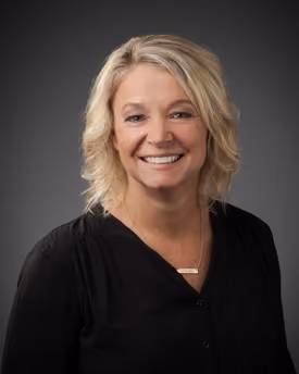 Professional portrait of Keri Guthrie smiling in a studio setting.