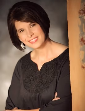 Professional portrait of Janet Altop smiling in a studio setting.