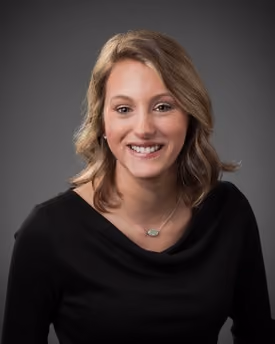 Professional portrait of Julia Kurtz smiling in a studio setting.