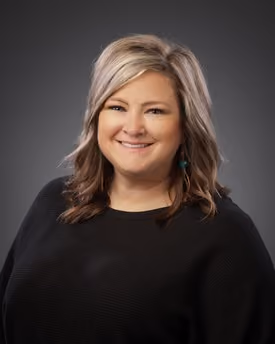 Professional portrait of Sherry McCoy smiling in a studio setting.