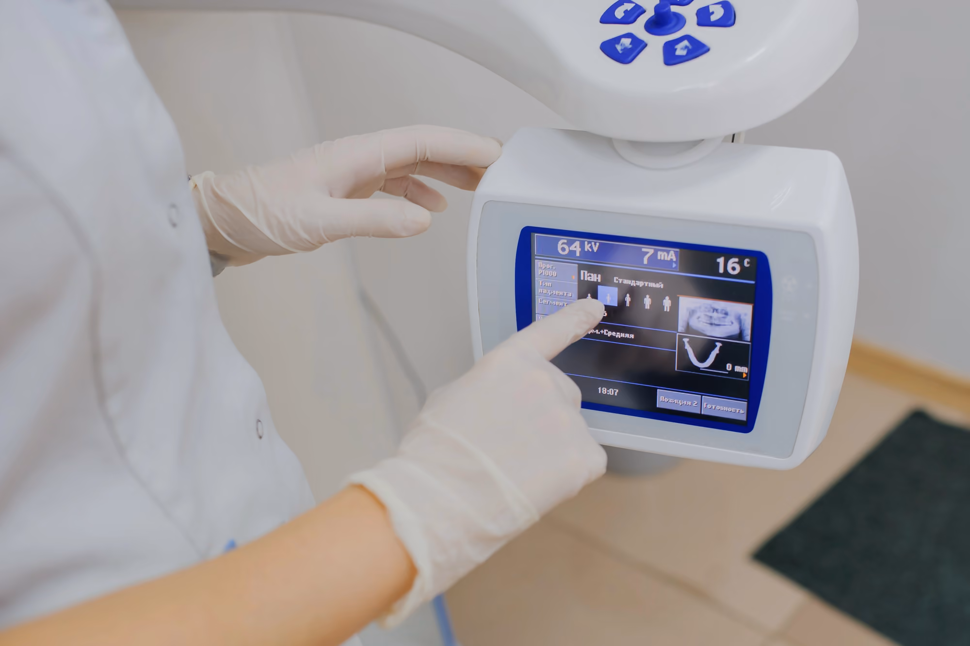 Dental professional operating a digital dental imaging system touchscreen.