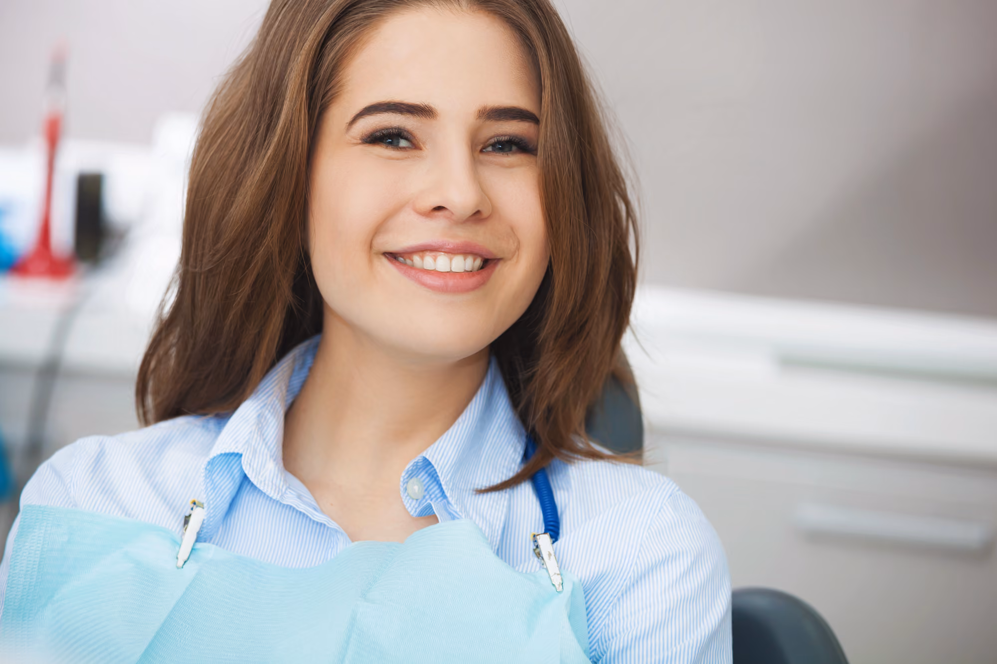Smiling patient seated comfortably in a dental chair before treatment.