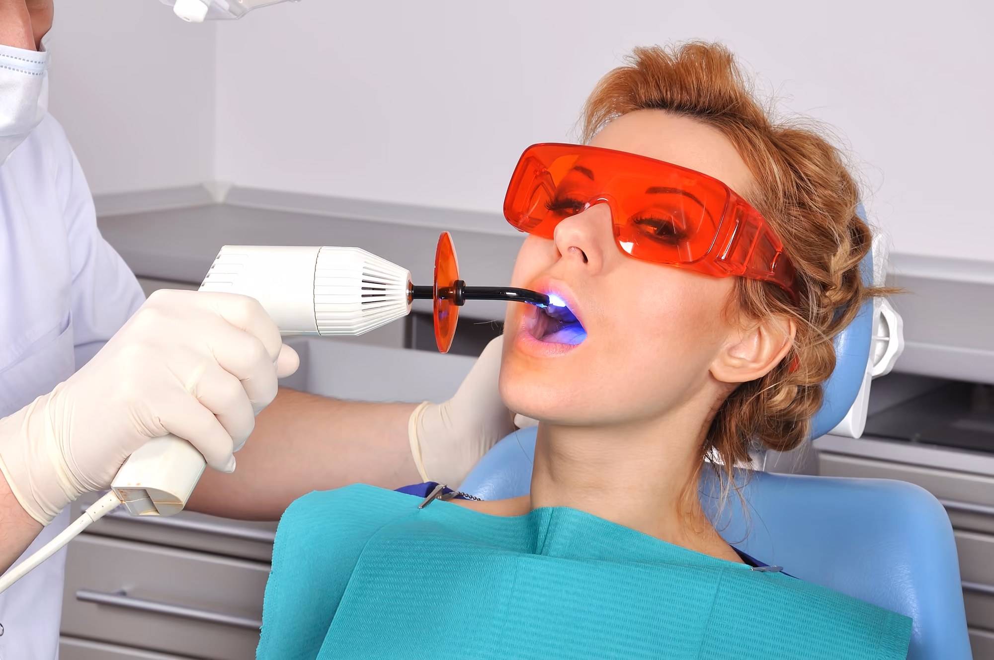 Patient wearing protective glasses during a laser teeth whitening procedure.