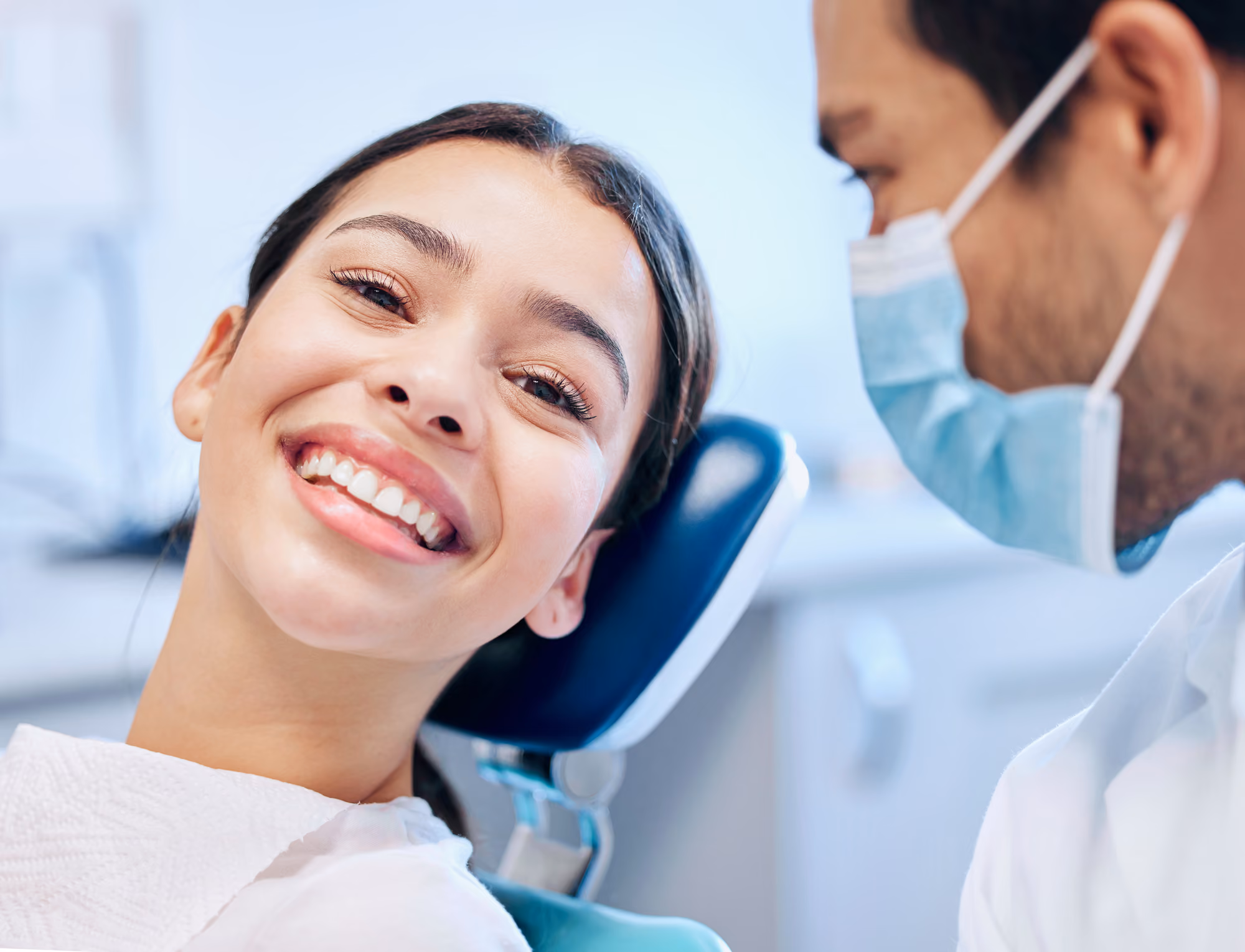 Dentist and patient smiling during a friendly dental consultation.