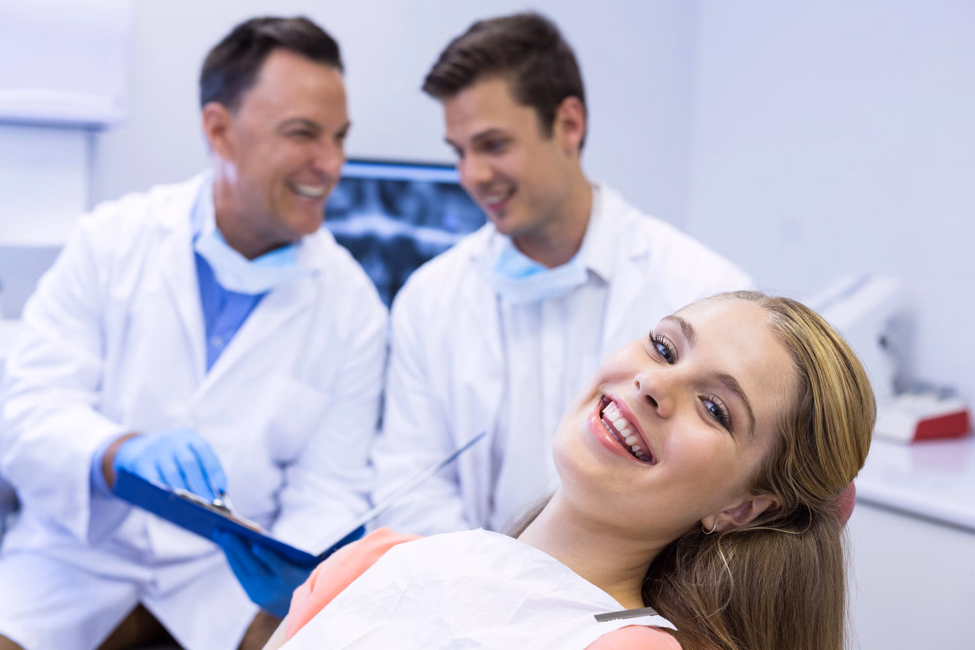 Patient smiling while seated in a dental chair after or during a treatment check.