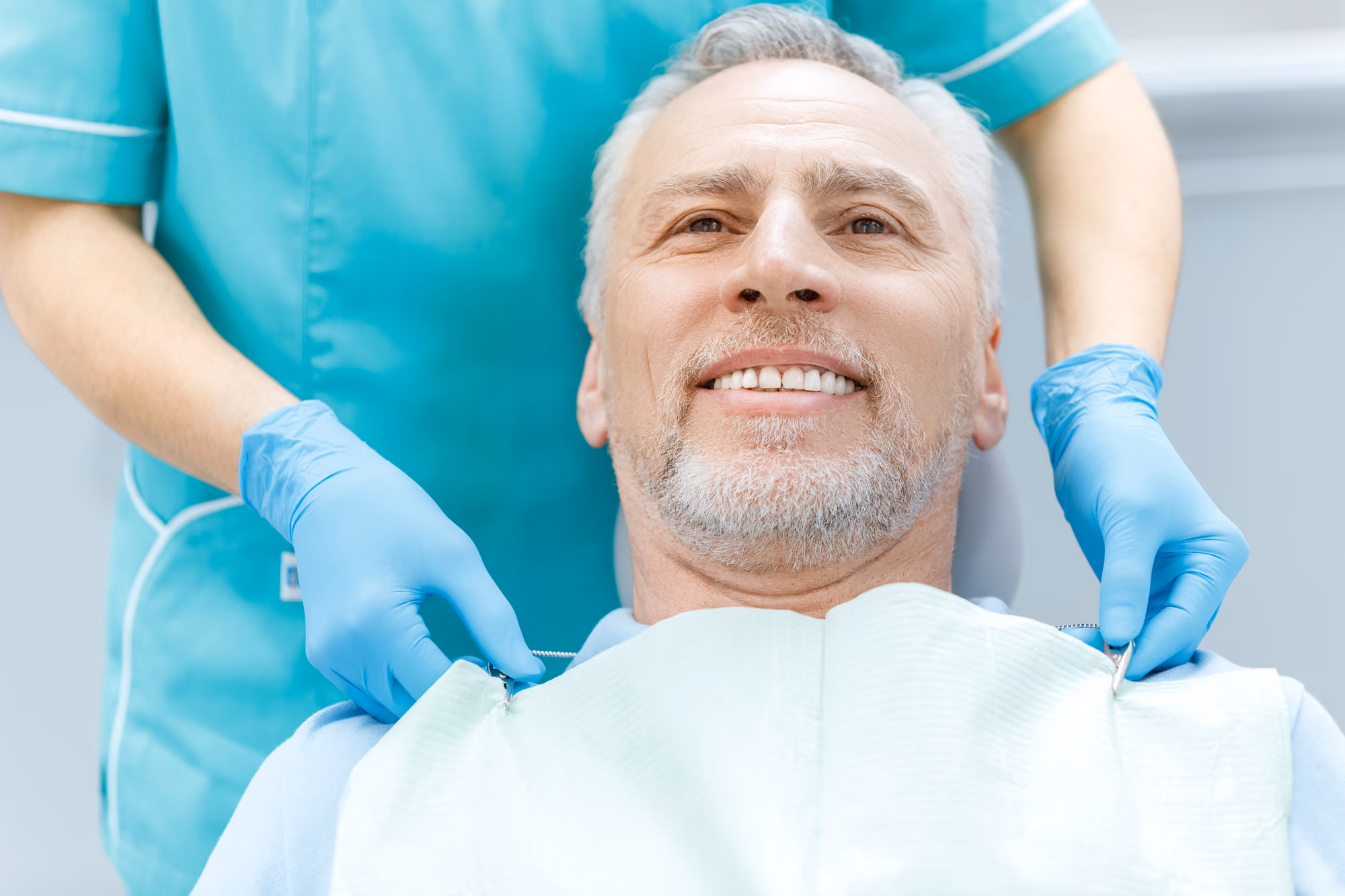 Patient smiling while speaking with a dentist during a chairside consultation.