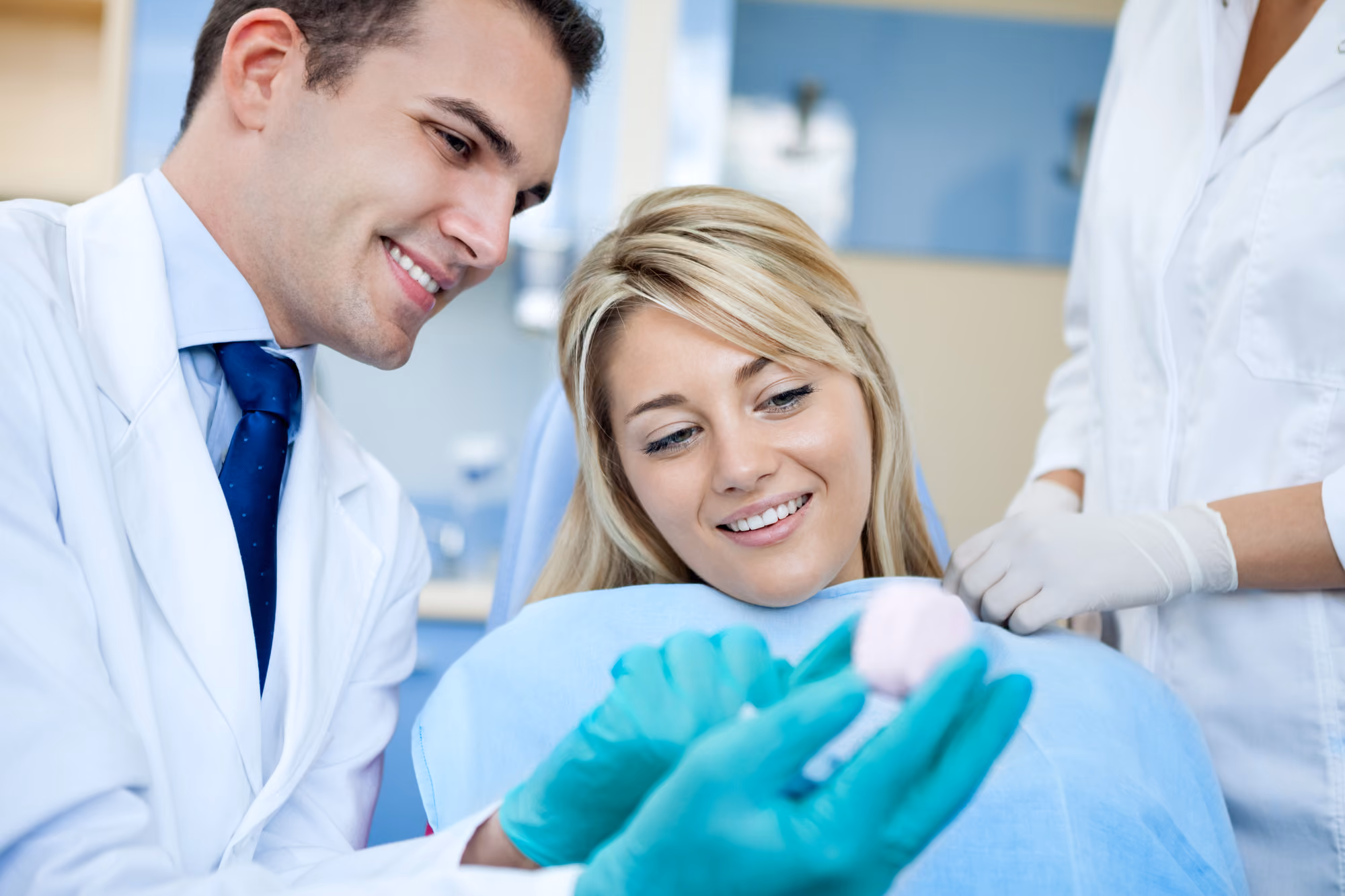 Dental team reviewing a model while discussing treatment options with a patient.
