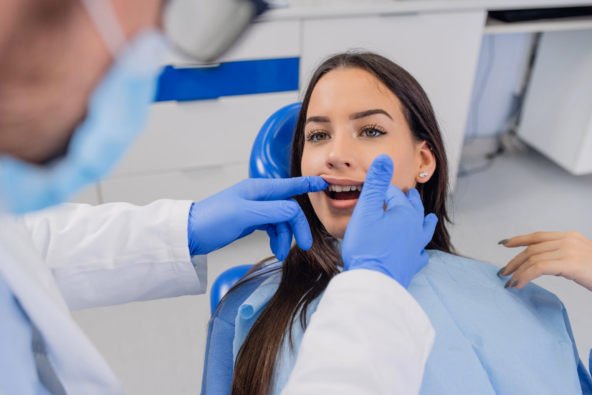 Dentist pointing inside a patient’s mouth during a dental examination.