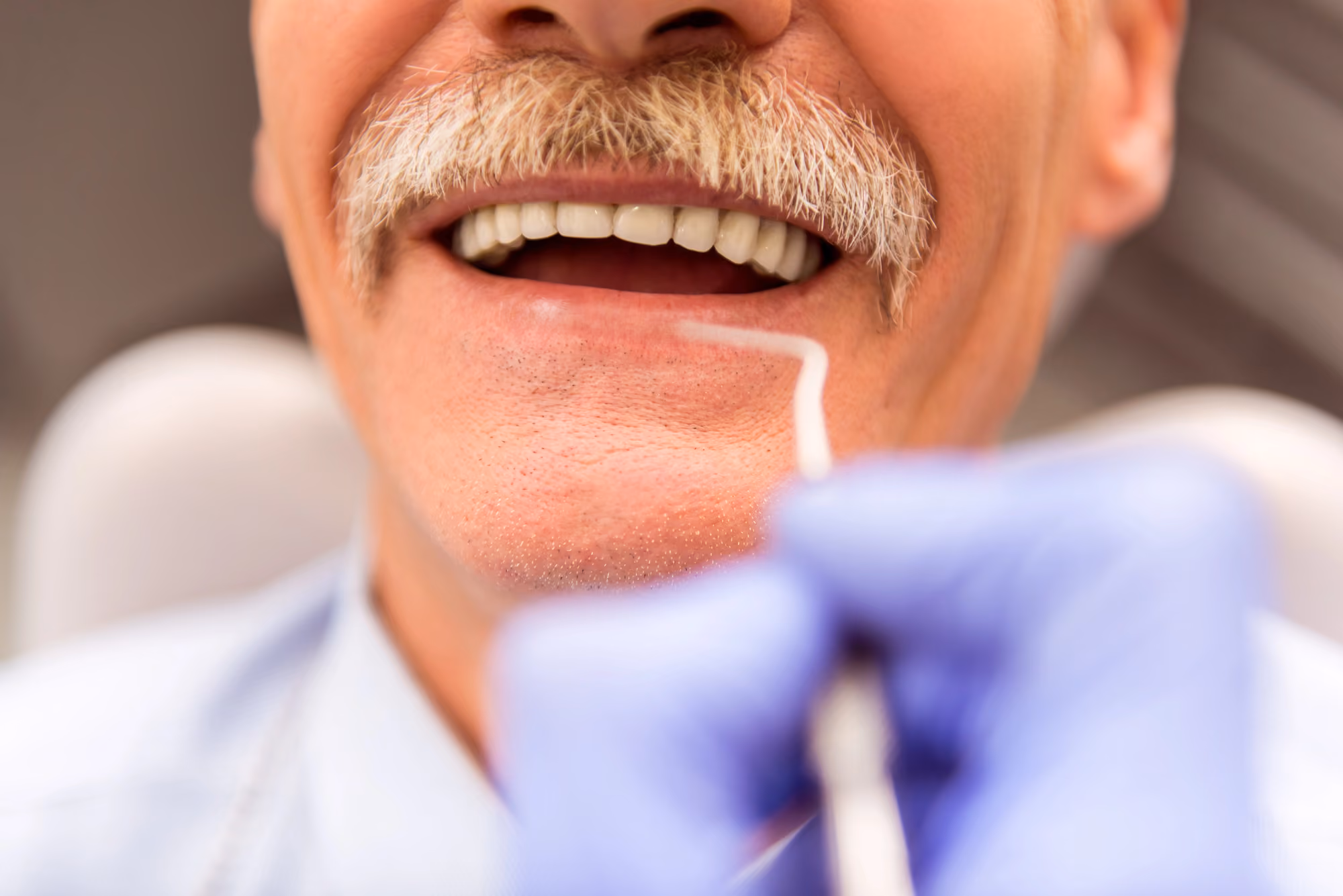 Senior patient receiving a dental examination and smile evaluation.
