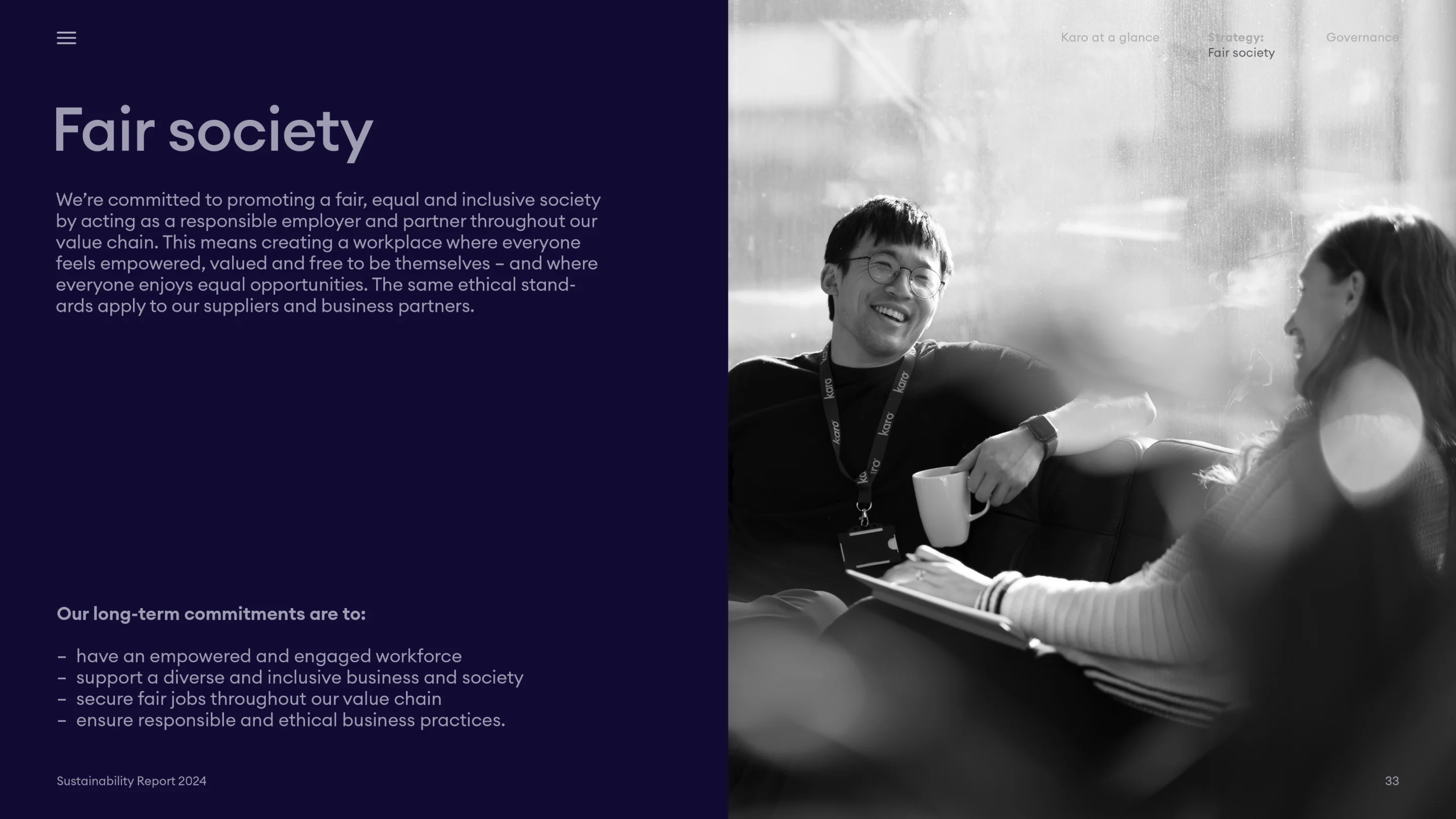 Two colleagues smiling and chatting on a couch, with one holding a coffee mug and the other a notebook, next to text about promoting a fair and inclusive society.