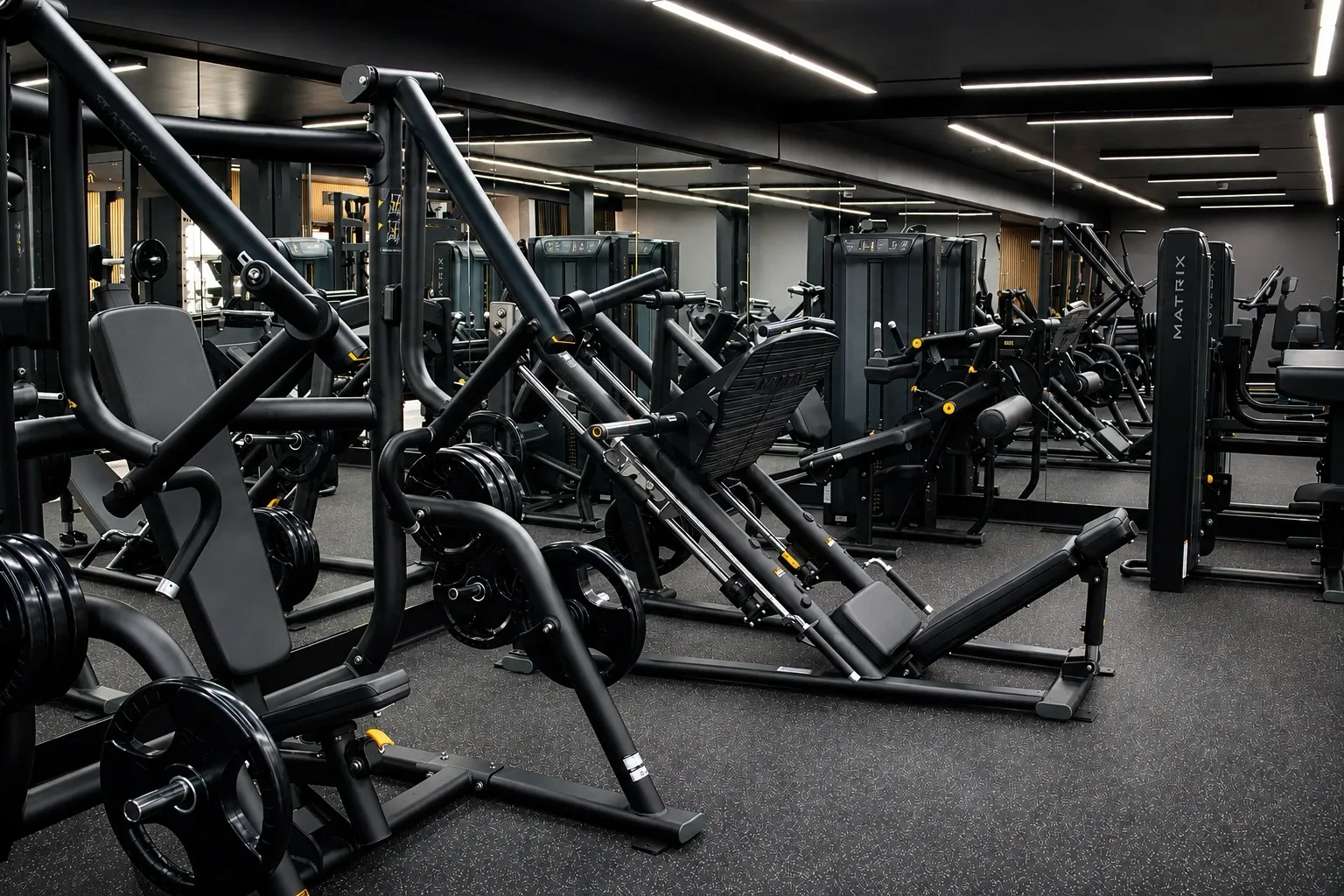 Intérieur d'une salle de sport moderne avec des équipements de musculation, un sol noir avec des éclats, un plafond noir avec des lumières LED blanches en forme de lignes géométriques, et des personnes s'entraînant.