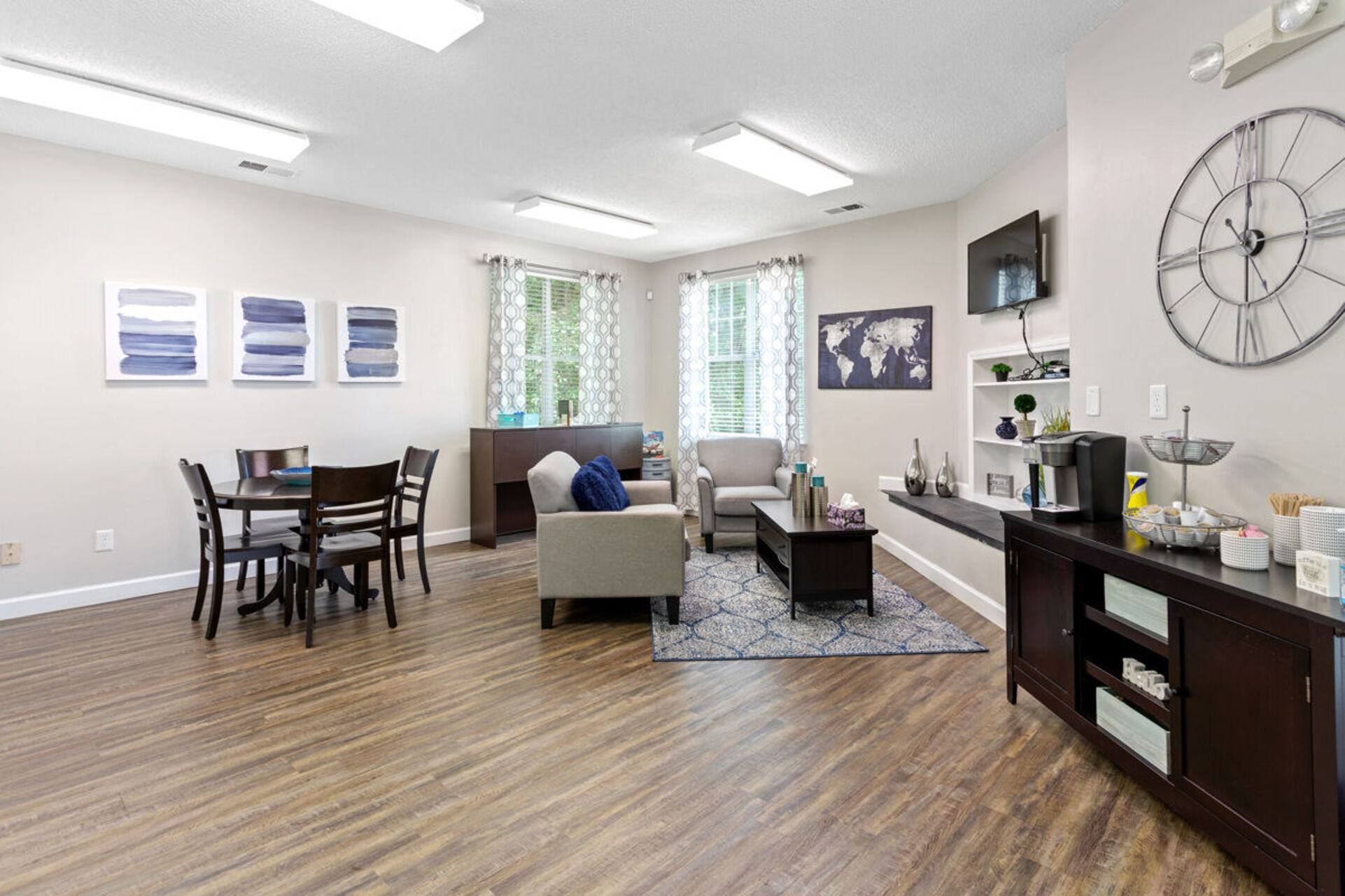 Clubhouse lounge with sofa, coffee table, and tv and view of coffee bar