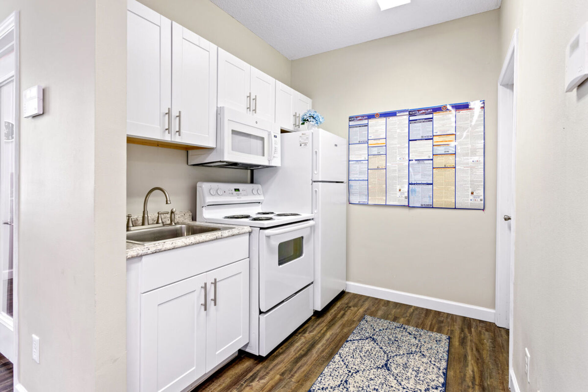 Model kitchen with white appliances and white cabinets
