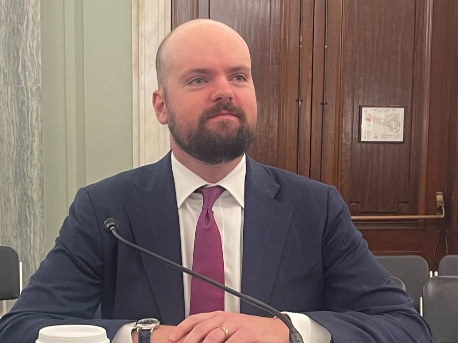 A bald man in a wool suit in July testifies before Congress on behalf of the National Small Business Association regarding exporting opportunities for small business.