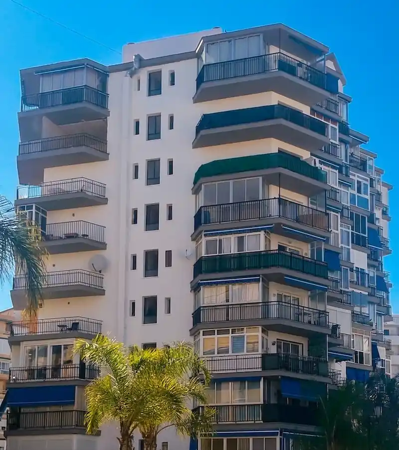 Edificio amarillo con balcones grises